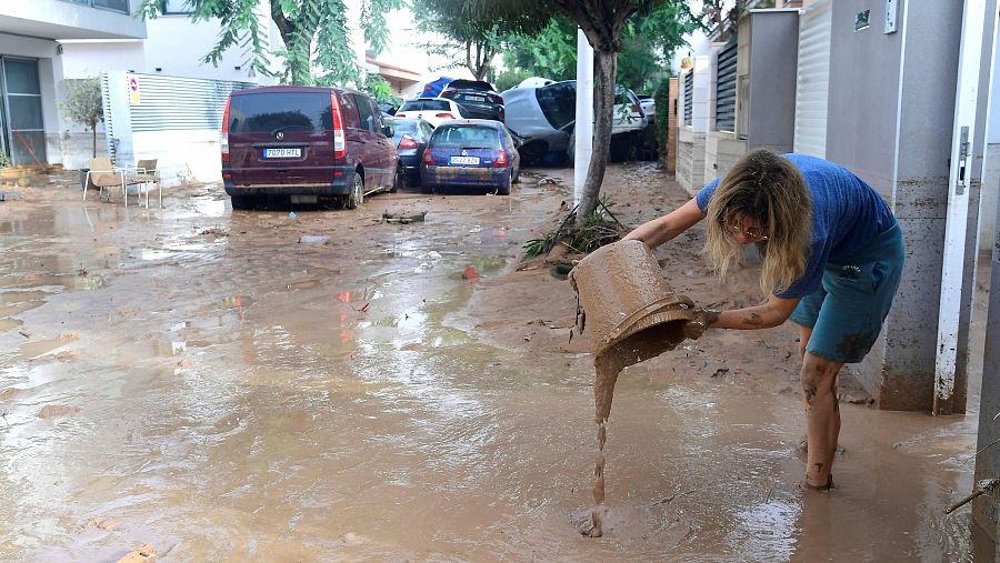 Una mujer intenta sacar barro de su casa con un cubo en Picuana