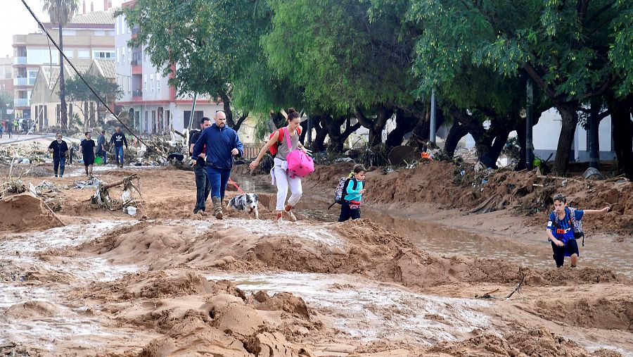 Imagenes de gente andando entre las calles inundadas en Picanya, Valencia.