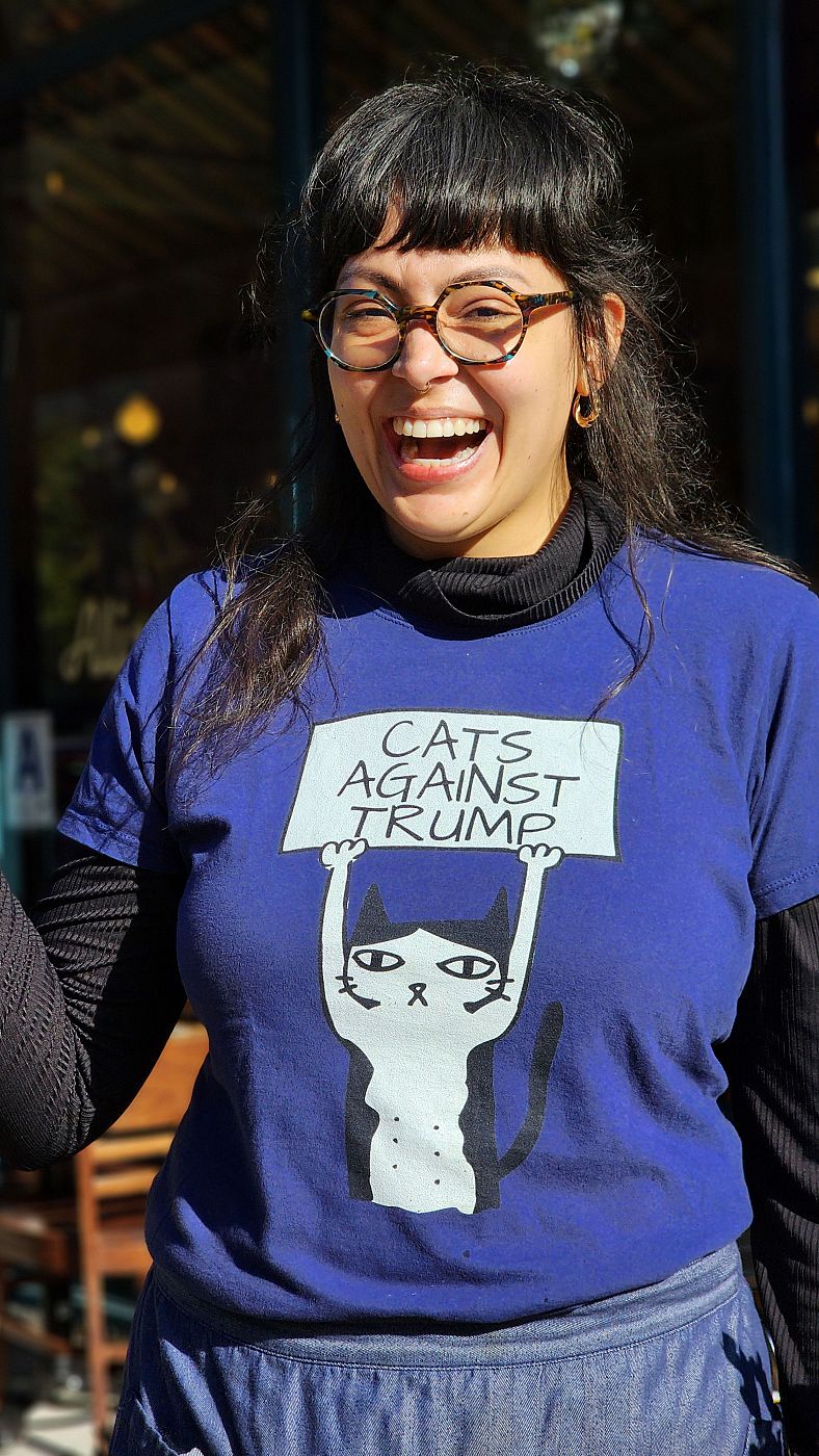 Una mujer luce una camiseta que dice 'Gatos contra Trump