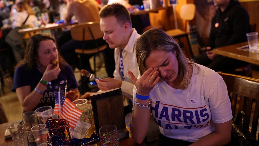 Estadounidenses demócratas reaccionan mientras miran la cobertura de las elecciones durante una fiesta de observación nocturna de las elecciones en un pub de Londres