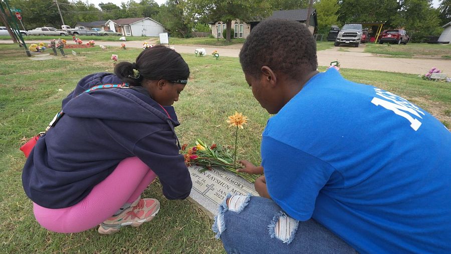 Vashunte Settles, acompañada de su hija, visita la tumba de su hijo D’Evan McFall, muerto por un tiro de una menor en Dallas (Texas) en 2023.