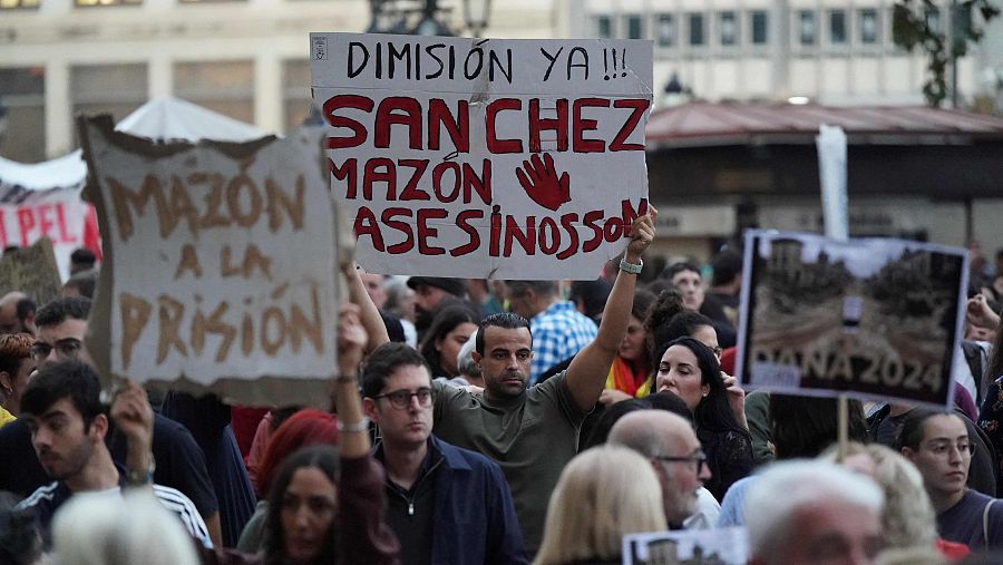 Un grupo de personas sostiene pancartas durante la manifestación en contra de la gestión de Sánchez y Mazón por la DANA