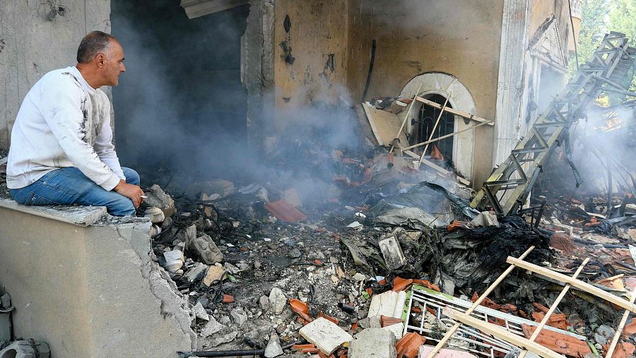 Un hombre observa la destrucción aún humeante en el lugar de un ataque aéreo israelí dirigido contra un barrio de Baalbeck