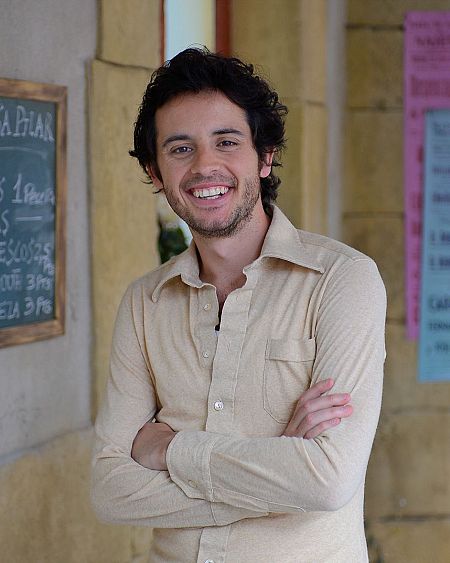 El actor Gabriel de 'Gran Reserva. El Origen' sonríe a la cámara con los brazos cruzados.