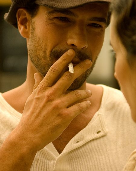 Iván Sánchez, como Antonio en 'Amar en tiempos revueltos', fuma un cigarrillo.