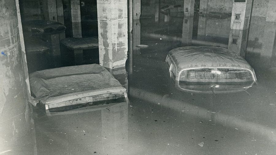 Coches parcialmente sumergidos en un garaje inundado. No se identifican personajes públicos.