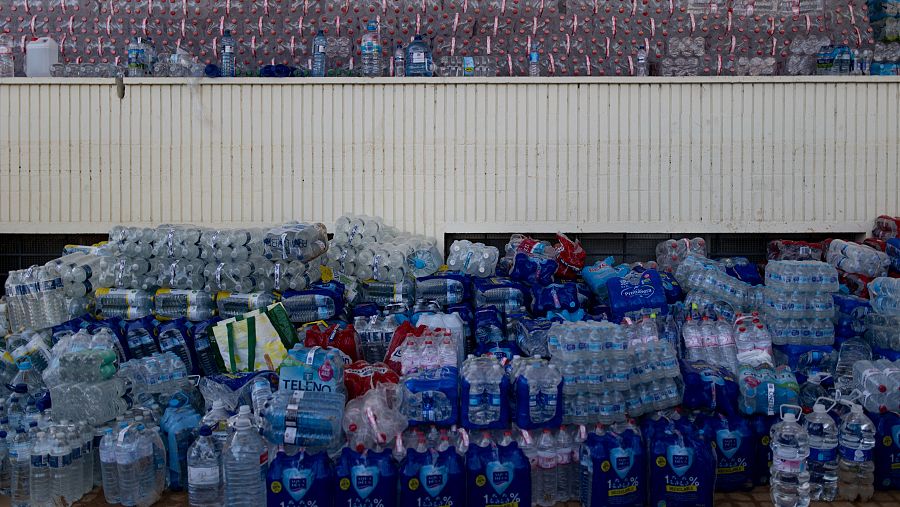 Montones de botellas de agua mineral empaquetadas y listas para su distribución a zonas afectadas.