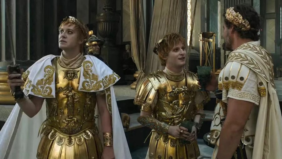 Los emperadores Geta y Caracalla, con armaduras doradas y capas blancas, conversan con un general romano.