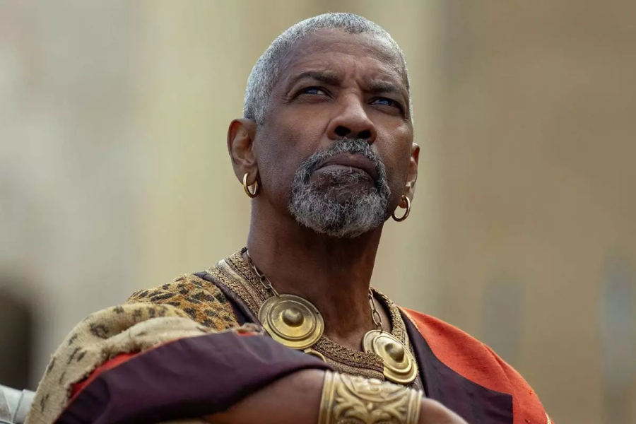 Denzel Washington como Macrino en 'Gladiator II', con vestimenta romana y barba canosa.
