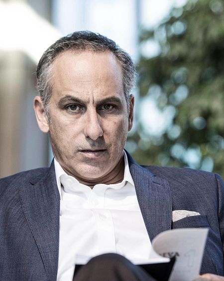 Alejandro Campoy, presentador de televisión, posa serio con documentos en la mano.