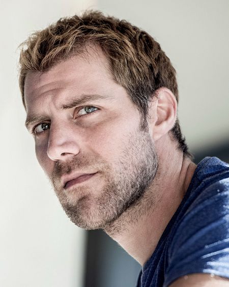 Retrato del actor español Jonás Berami con camiseta azul.