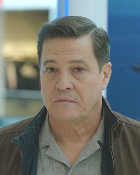 El actor Tito Valverde con expresión seria en un espacio público.