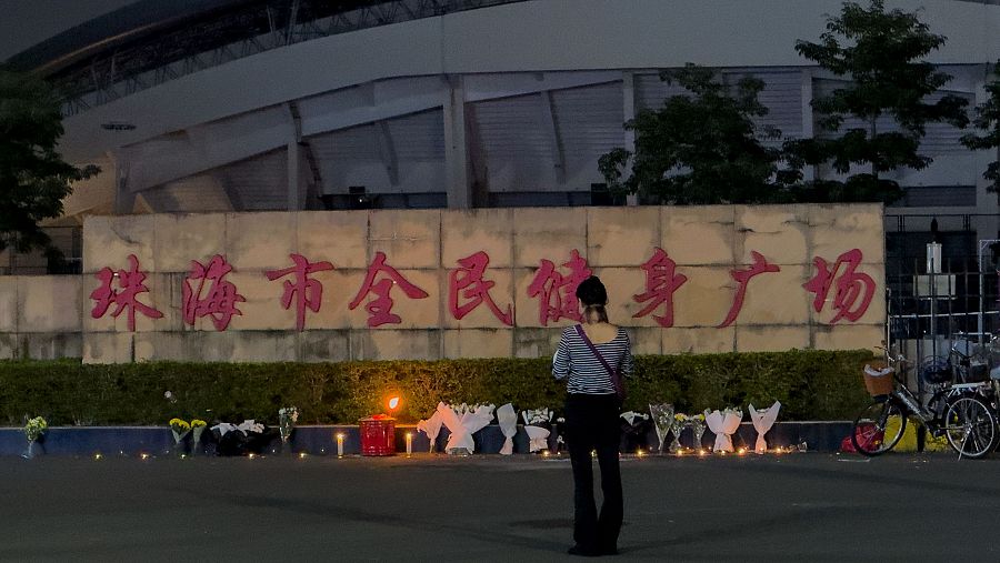 Una mujer observa las flores depositadas por las víctimas tras el ataque en Zhuhai