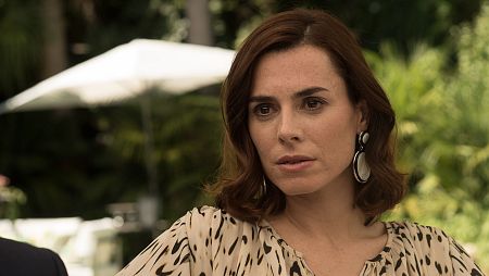 La actriz Beatriz Arjona con expresión seria, blusa estampada y pendientes, en un primer plano.