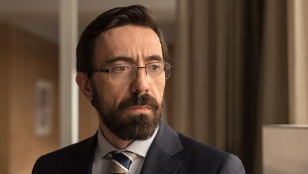 Víctor Gutiérrez, con gesto serio, lleva gafas y viste traje con corbata.