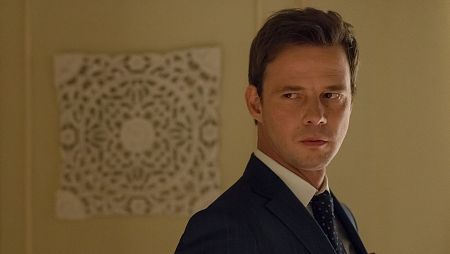 Rafael, con traje y corbata, mira seriamente hacia la derecha.