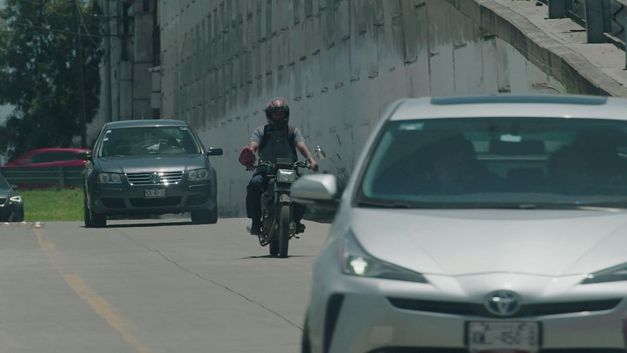 Motociclista circula entre el tráfico en una calle de Puebla, México.
