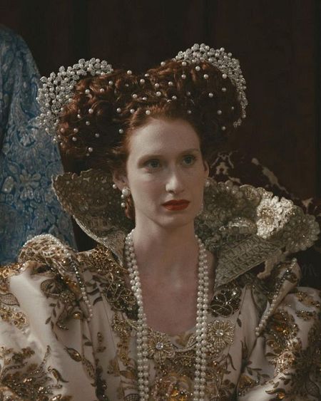 Michelle Jenner interpretando a la reina Isabel I con un vestido y peinado de época.