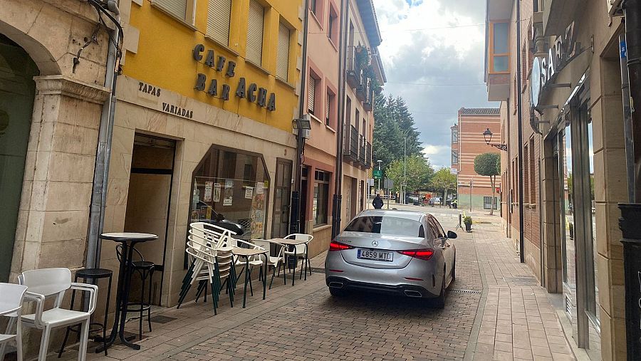 Calle estrecha con un Mercedes aparcado frente al 