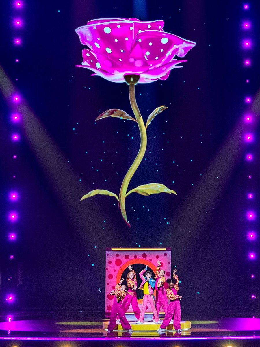 Chloe DelaRosa canta en Eurovisión Junior con sus bailarinas, bajo una rosa gigante.