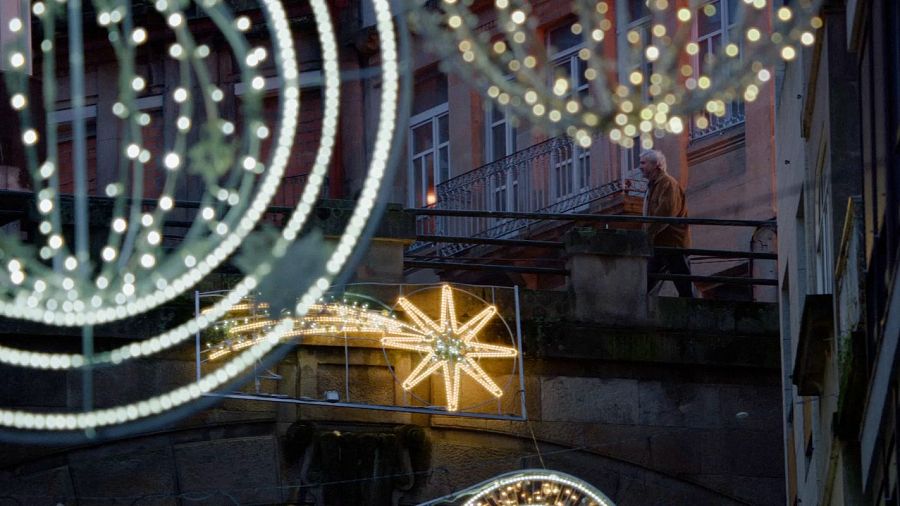 Julián pasea por Vigo en una escena del anuncio de la Lotería de Navidad 2024, bajo luces navideñas.