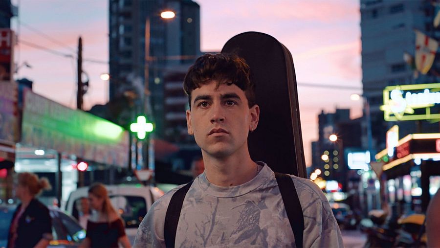El actor Àlex Monner, con una funda de guitarra, en una escena nocturna de la película 'El Cover'.