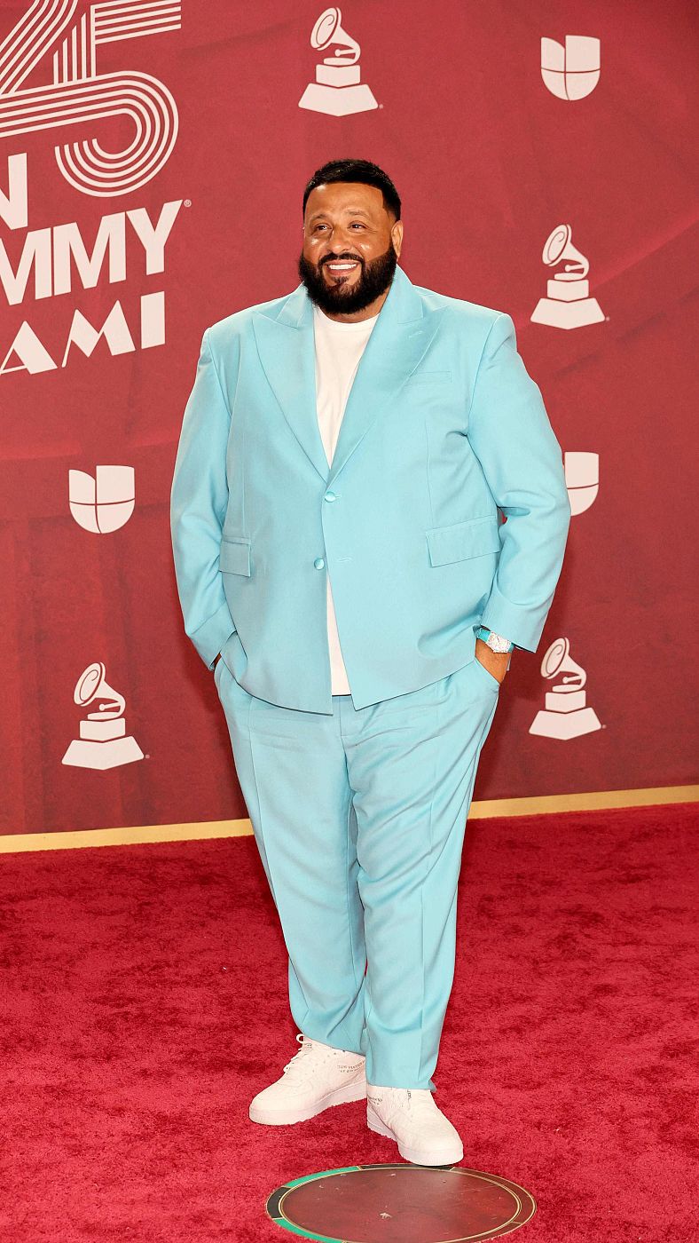 DJ Khaled en la alfombra roja de los Latin Grammy con traje azul claro y zapatillas blancas.