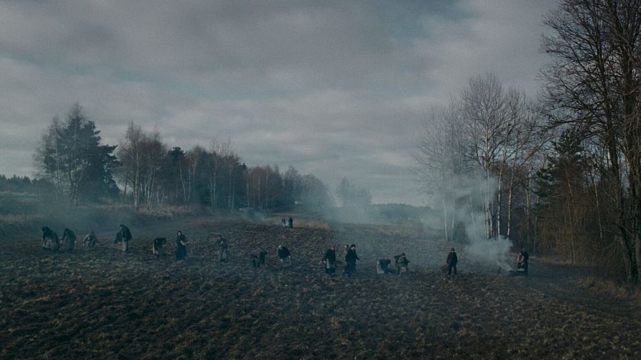 Grupo de personas trabajando en un campo labrado en una escena de 'El baño del diablo'.
