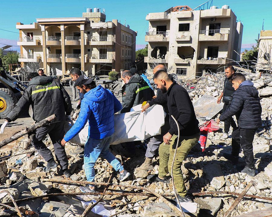 Rescatistas palestinos evacuan el cuerpo de un oficial de la defensa civil entre los escombros de un edificio en el valle de la Bekaa.