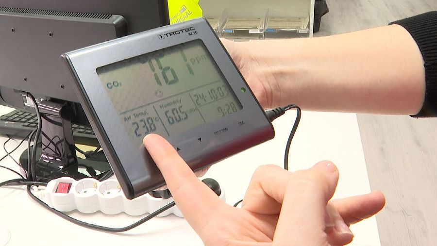 Medidor de CO2 mostrando 161 ppm, 23.8°C y 60.5% de humedad, manipulado por una persona.