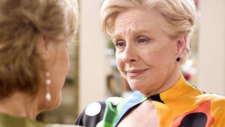 Primer plano de Blanca, actriz de la serie 'Las Chicas de Oro', con un vestido estampado y una expresión seria, en una escena de la serie.