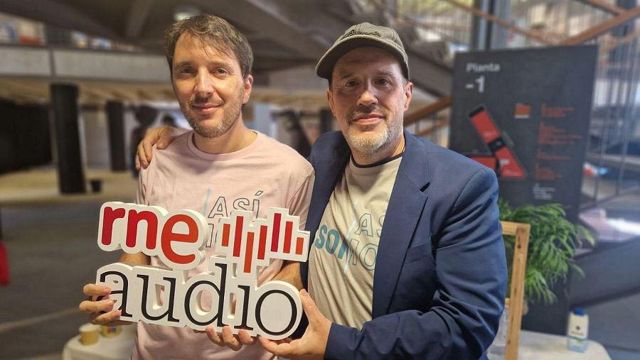 Molo Cebrián y Luis Muiño, en un evento de RNE, sostienen el logotipo de 'rne audio'.