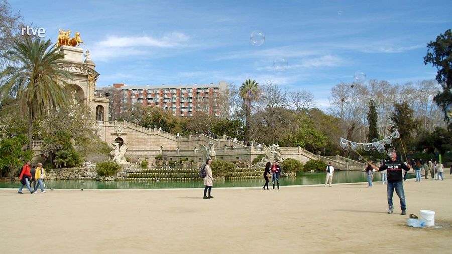 Día soleado en el Parque de la Ciutadella de Barcelona, con gente paseando y un artista haciendo pompas de jabón.