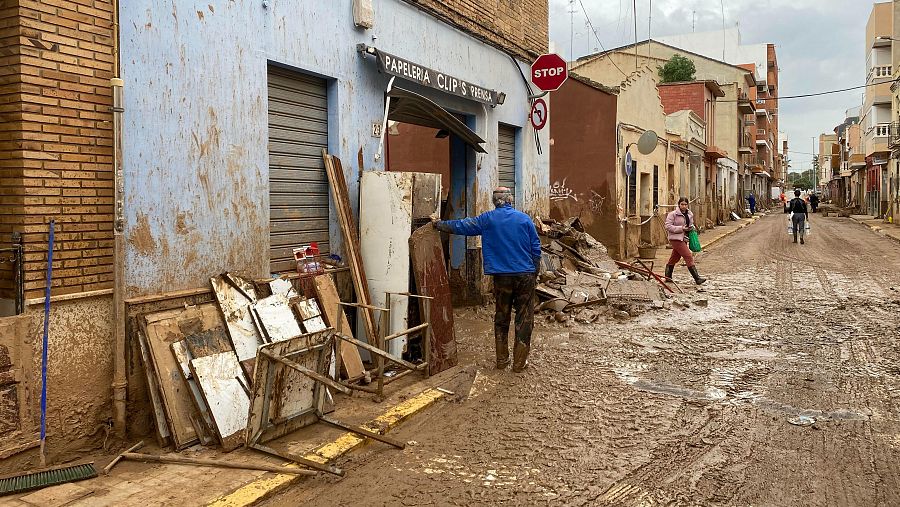 Los deshechos se amontonan en una calle de Massanassa frente a lo que era una papelería