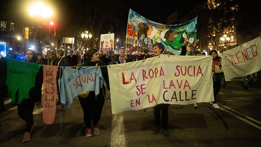 Manifestación 25N en Barcelona: mujeres marchan con pancartas contra la violencia de género.  Se ven lemas como 