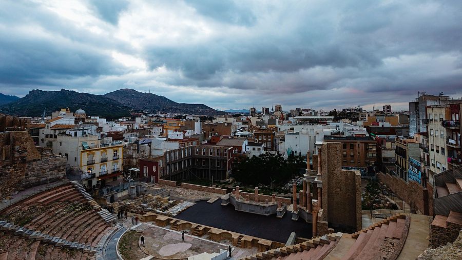 Vista panorámica del Teatro Romano de Cartago Nova en Cartagena, mostrando sus gradas, escenario y el contraste con la arquitectura moderna circundante.