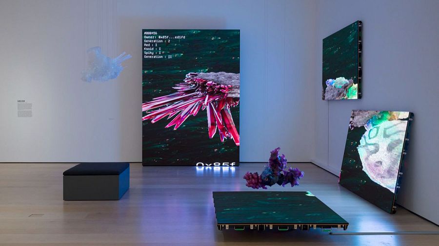 Instalación de Michael Joo: 'Organic Growth: Crystal Reef'. Pantallas con imágenes abstractas de cristales y esculturas de cristal. Atmósfera contemplativa.