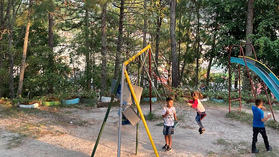 Niños jugando en un parque infantil con columpios y tobogán en Santa Rosa de Copán, Honduras.  Foto cedida por Familias Transnacionales.