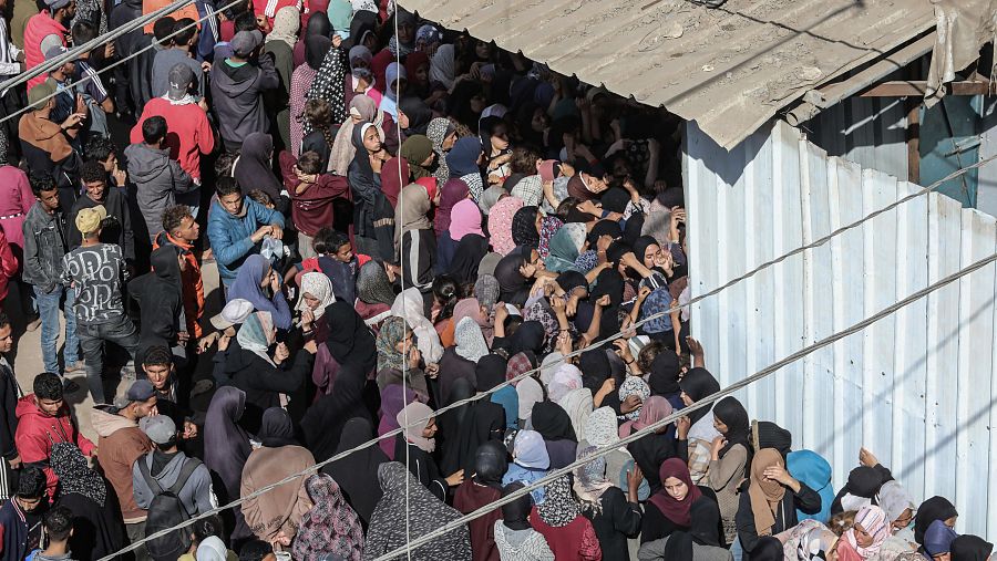 Palestinos hacen cola para recoger pan en Deir El-Balah