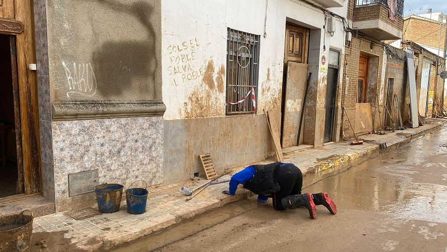 Un vecino desatasca una alcantarilla en Massanassa