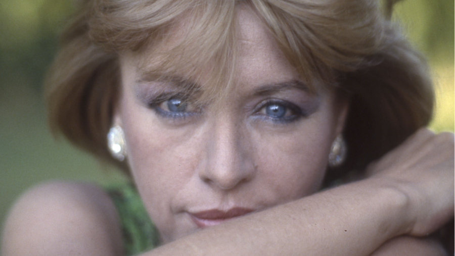 Retrato de Mari Trini: cantante española con cabello rubio, pendientes brillantes y vestido verde. Mirada serena y directa a cámara.