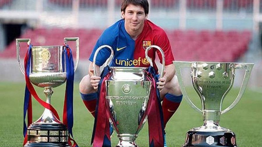 Messi con los trofeos de Liga, Copa del Rey y Champions League del triplete del Barça 2009.  Camiseta del Barça con logo UNICEF.  Imagen de archivo.
