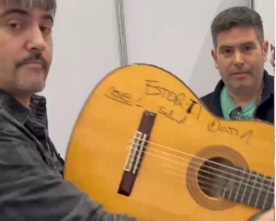 Los hermanos cantantes del grupo Estopa, David y José Muñoz, posando junto a una de las guitarras firmadas por ellos.