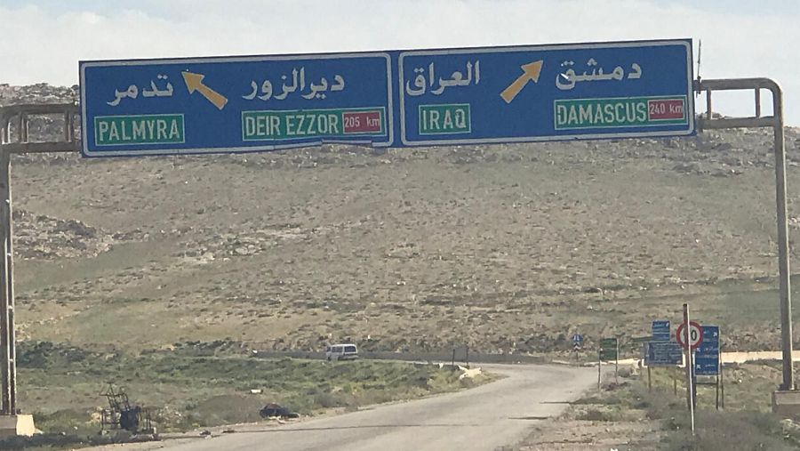 Letrero de señalamiento en una carretera siria entre Homs y Palmira en el que muestra destinos hacia Deir Ezzor, Irak y Damasco, la capital del país