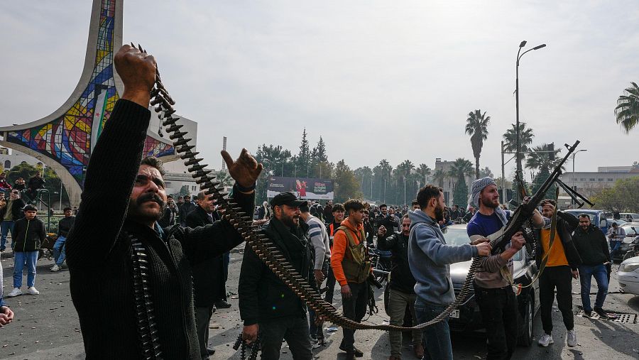 Combatientes rebeldes disparan al aire mientras celebran la toma de Damasco