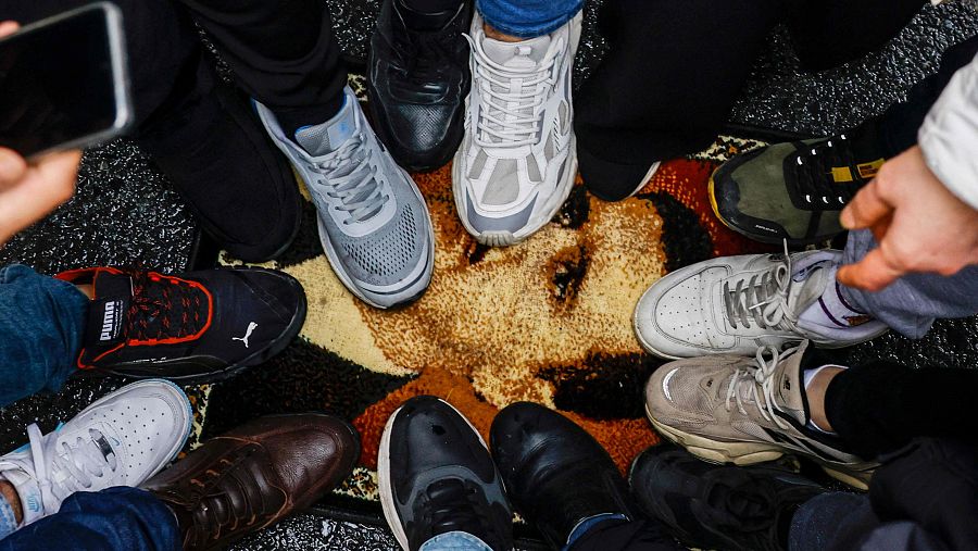 Manifestantes pisotean una alfombra con un dibujo de Bachar al Asad