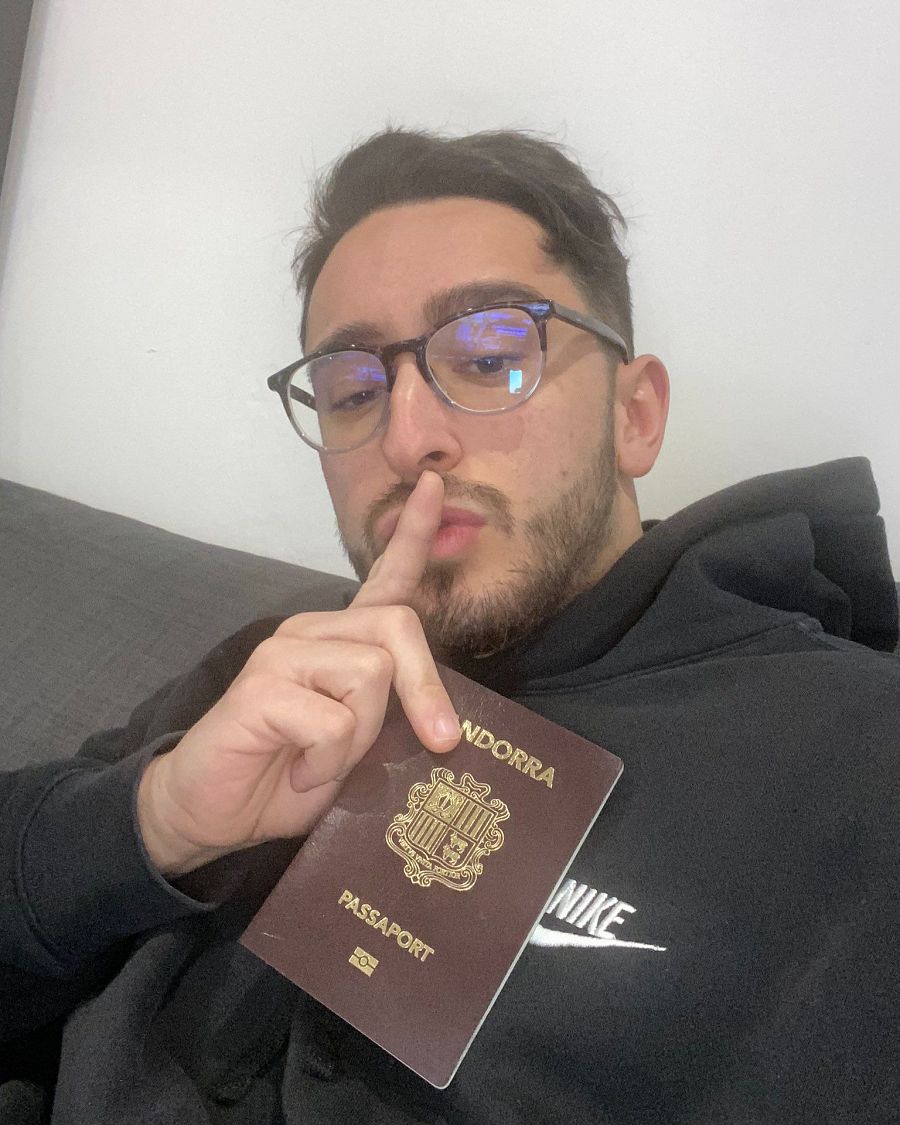 Selfie de Spursito mostrando su pasaporte andorrano.  Gafas, sudadera Nike negra y gesto de silencio.  Sugiere discreción sobre su mudanza.