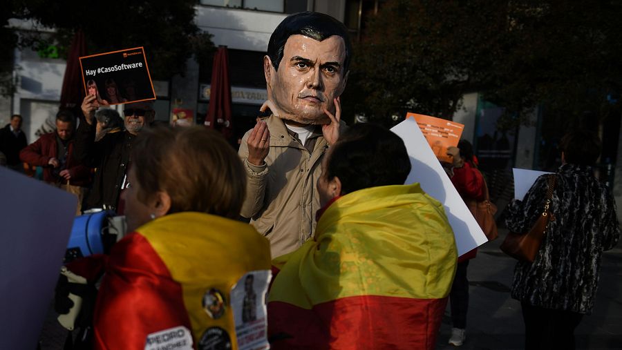 Protesta en juzgados con carteles, una cabeza de cartón de Sánchez y el hashtag #CasoSoftware.  Manifestación contra Sánchez y su esposa, posiblemente por un asunto judicial relacionado con software.