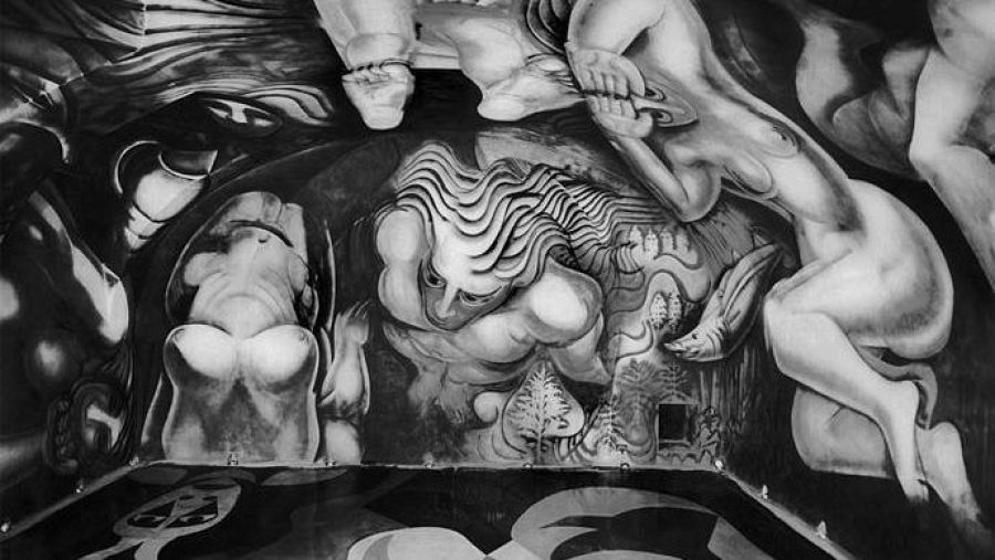 Foto en blanco y negro de un mural de Siqueiros, década de 1930, con figuras humanas desnudas en poses dinámicas y estilo muralista. Perspectiva desde abajo.
