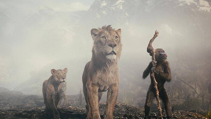 Mufasa, Nala, Scar y Rafiki en un paisaje montañoso y brumoso.  Mufasa mira hacia adelante con expresión seria; Nala está a su lado; Rafiki sostiene un bastón.